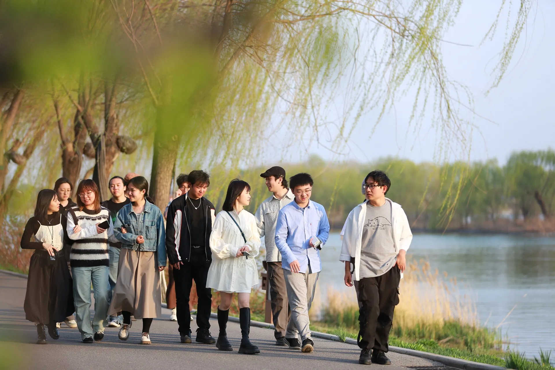 北京站，同学们在春日柳树下沿运河并肩散步